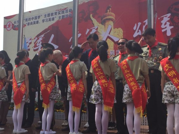 学生代表在主席台给巡讲团成员戴红领巾